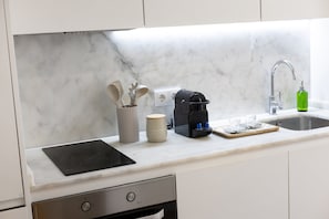 A kitchen with a marble countertop, a coffee maker, a mug, and a knife holder. - Lapa Design Studio with Workspace (Porto)
