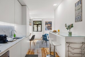 A modern kitchen with a window, bar stools, and a view of a cityscape. - Lapa Design Studio with Workspace (Porto)