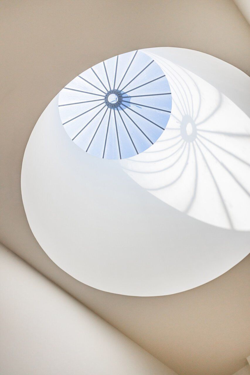 Ein modernes architektonisches Design mit einer kreisförmigen Struktur und einer zentralen Lichtvorrichtung.