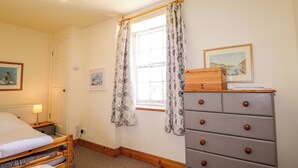 A bedroom with a bed, dresser, window with curtains, and two framed pictures on the wall. - 6 Hill Street (Banff)