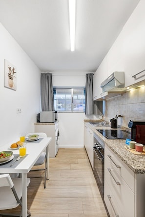 Une cuisine compacte avec un coin repas, une fenêtre et une vue sur la ville.