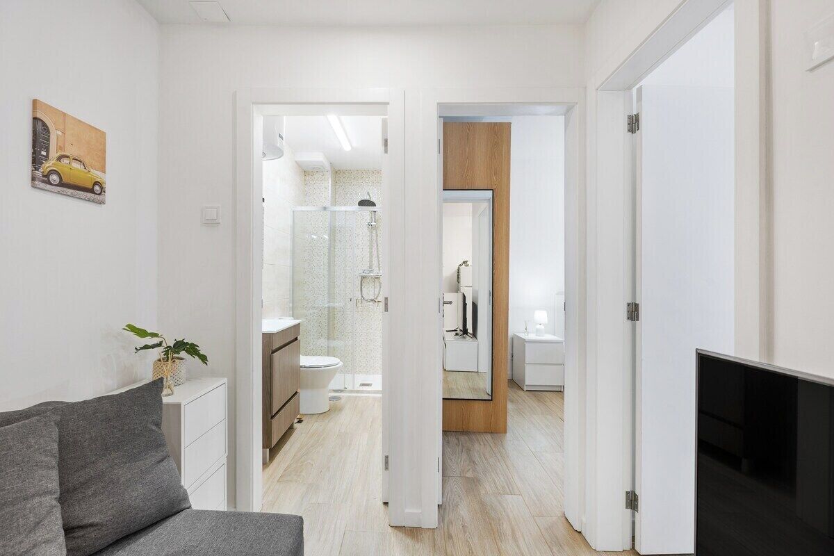 Ein modernes Apartment mit Wohnbereich, einem Badezimmer mit Dusche und einem Schlafzimmer.
