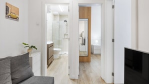 A modern apartment with a living area, a bathroom with a shower, and a bedroom. - Smart Stay in Gaia | Cozy & Work-Ready (Vila Nova de Gaia)