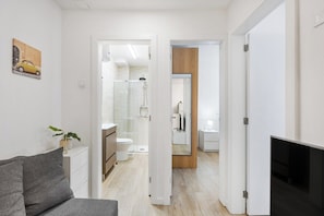 Un appartement moderne comprenant un espace de vie, une salle de bain avec douche et une chambre à coucher.