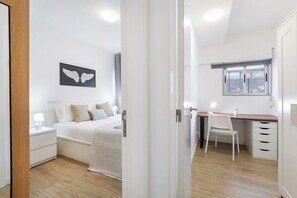 Une chambre à coucher avec un lit, une table de chevet et une fenêtre.