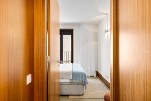 Ein Schlafzimmer mit Bett, Fenster und Tür.