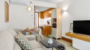 A modern apartment with a living room, kitchenette, and a dining area.