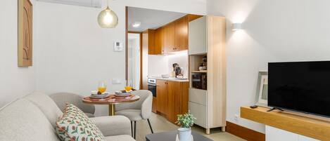 Un apartamento moderno con sala de estar, kitchenette y comedor.
