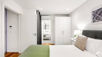 A bedroom with a bed, a nightstand, a lamp, and a wardrobe.