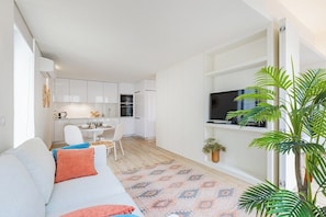 A modern living room with a sofa, a dining table, and a kitchen in the background. - Urban Style in Bonfim | Porto (Porto)