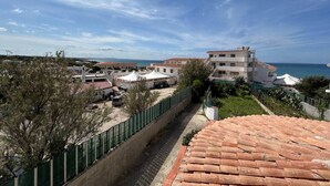 Zona residencial costera con edificios, un paseo pavimentado y vistas al mar.