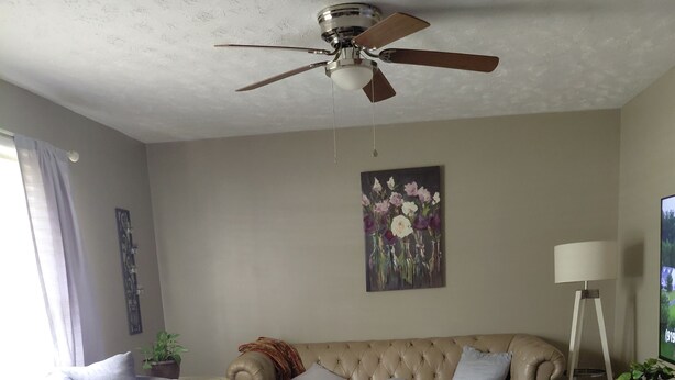 A living room with a beige sofa, a grey sofa, a wooden coffee table, a ceiling fan, a floor lamp, and a painting on the wall. - Quiet, peaceful home located near Fort Bragg and Cape Fear Medical Center (Fayetteville)