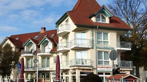 A multi-story building with balconies, a sign for 'WALDAUS,' and various storefronts including 'Ristorante' and 'Marco Polo.' - Apartment for 4 People (44 m²) in Zempin (Seaside Resort) (Zempin)