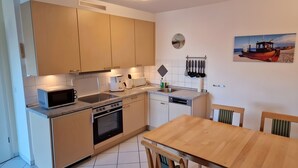 A modern kitchen with a microwave, toaster, sink, and dishwasher. - Apartment for 4 People (44 m²) in Zempin (Seaside Resort) (Zempin)