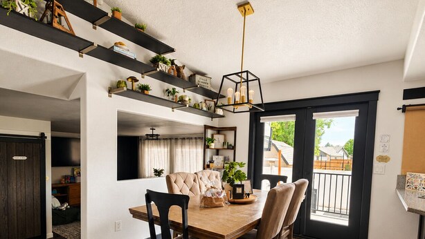 A dining area with a wooden table, four chairs, and a chandelier. - The Hive Hideaway (Meridian)