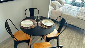 A dining table with two plates, two glasses, and a black tablecloth. - Rbk Cómodo Studio con gran ubicación (Santiago)