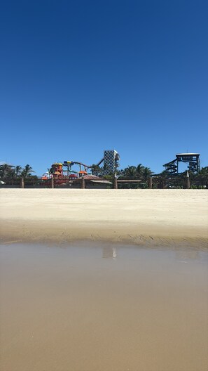 A sandy beach with a water park in the background. - ApartHotel Versilia Beach- Close to complete Beach Park + Swimming Pool (Aquiraz)