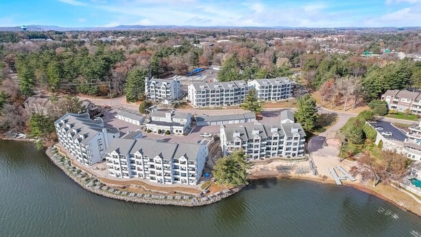 A waterfront hotel with multiple buildings, a dock, and a lake.