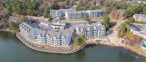 A waterfront hotel with multiple buildings, a dock, and a lake.