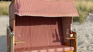 A beach cabana with striped fabric walls and a bench. - Apartment Ariane with Wi-Fi (Zempin)