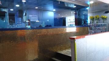 A reception area with a glass partition, a calendar, and a wall with a grid pattern.