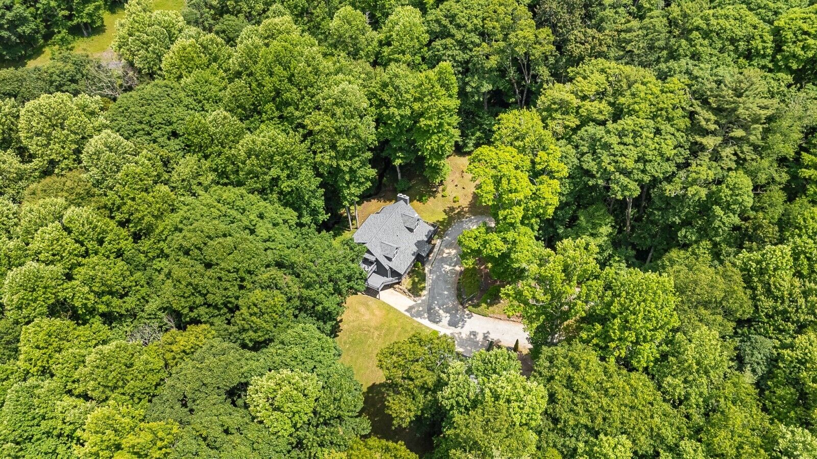Eine Luftaufnahme eines Hauses, umgeben von dichtem Wald.