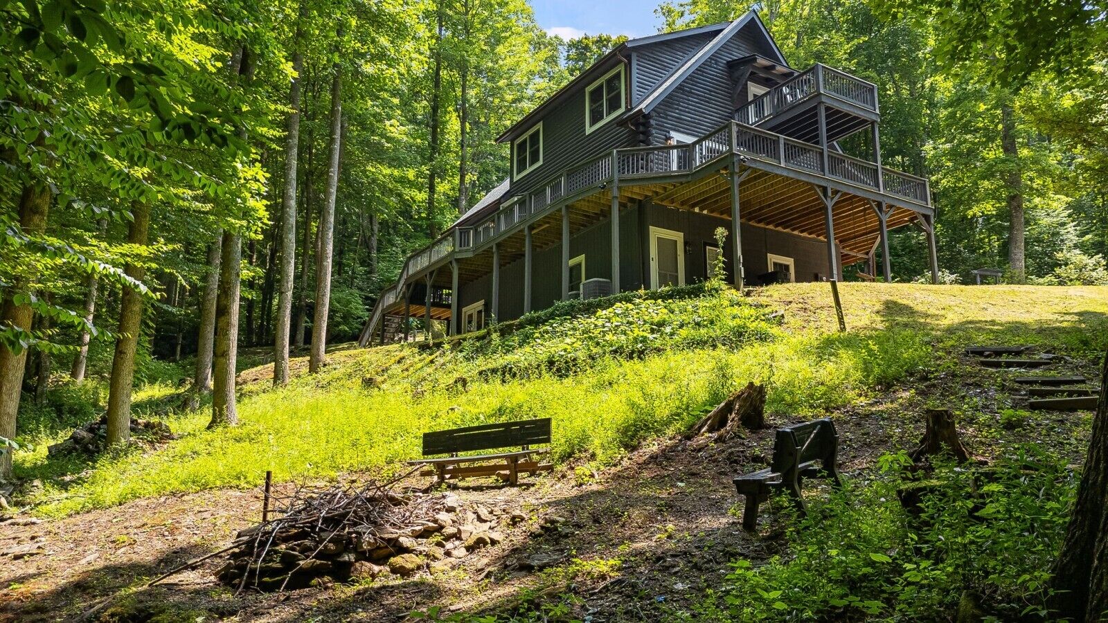 Eine Hütte mit Balkon, umgeben von Wald.