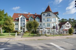 A multi-story building with a red-tiled roof, a central tower, and a reception area. - Apartment 'Strandnah' with Private Terrace and Wi-Fi (Zempin)