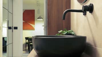 Een moderne badkamer met een grote, donkergekleurde wastafel in een houten aanrechtblad.