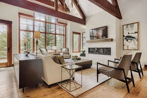 A spacious living room with a fireplace, large windows, and a modern design. - Escape to the heart of the Rockies! Luxury 5 bedroom home in Silverthorne! (Silverthorne)