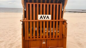 Un cabanon de plage avec une pancarte indiquant « AVA » et une serrure sur la porte.