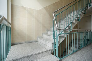 Eine Treppe mit türkisblauen Geländern und Granitschrittsteinen.