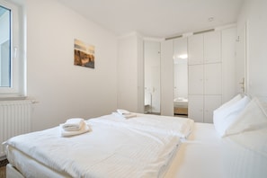 A hotel room with a bed, a window, a door, and a mirror. - Apartment 'Ava' with Balcony and Wi-Fi (Zempin)