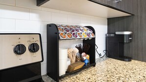 Eine Küche mit Kaffeemaschine, Toaster und Kapselhalter.