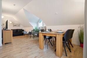 Un loft moderno con comedor, sofá y televisor.
