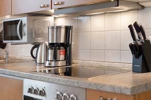 A kitchen with a microwave, coffee maker, and knife block. - Apartment "Tine" with Balcony and Beach Chair in Summer (Zempin)
