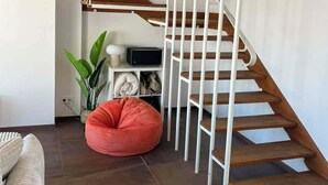 Ein modernes Interieur mit einer Wendeltreppe, einem Sitzsack und einer Pflanze.