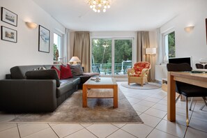 Una sala de estar moderna con un sofá, una mesa de centro y un comedor con una silla y una mesa.