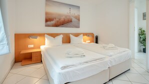 Habitación de hotel con una cama grande, dos mesitas de noche y un cuadro en la pared.