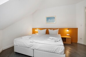 Un dormitori modern amb un llit individual, una taula de nit i un quadre a la paret.