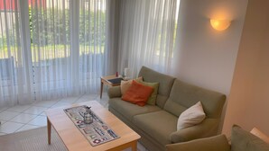 A living room with a sofa, a coffee table, and a lamp. - Apartment 'Lotte' with Wi-Fi (Zempin)