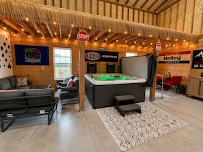 Un espacio interior acogedor con un jacuzzi, un sofá y un comedor.