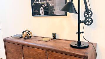 A wooden cabinet with a vintage car photograph above it.
