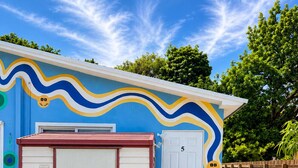 A house with a garage, a door marked with the number 5, and a colorful mural on the wall.