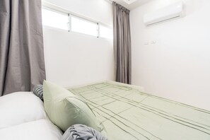 A room with a bed, a window, and an air conditioning unit. - Indigo | Designer 2BR/2BA Apartment, Gated Complex, Pool & Beach Access - Juan Dolio (Playa Juan Dolio)