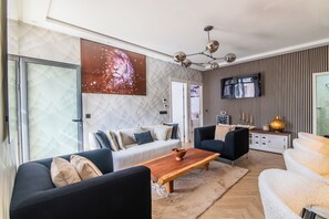 A modern living room with a sofa, coffee table, and TV. - DAR DYAFA VIP (Agadir)