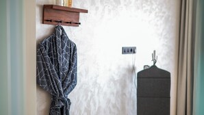 Un baño con toallero, bata y perchero.