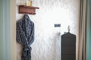 A bathroom with a towel rack, a robe, and a hanging garment. - DAR DYAFA VIP (Agadir)