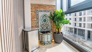 Una habitación moderna con una pared de azulejos, una planta en maceta y una ventana con vistas a una obra.