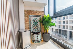 A modern room with a tiled wall, a potted plant, and a window overlooking a construction site. - DAR DYAFA VIP (Agadir)